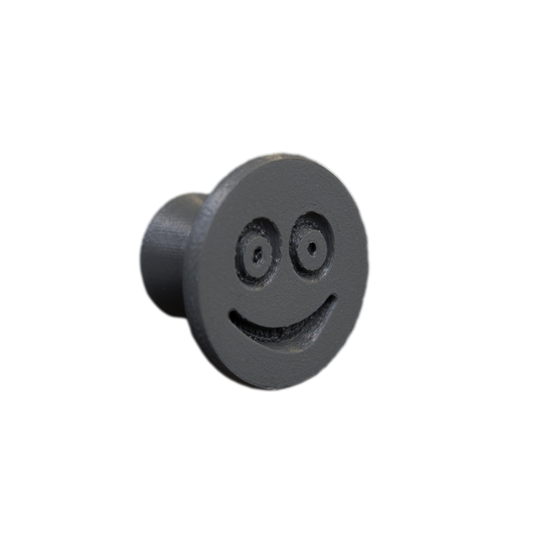 Flexible furniture knob with smile, graphite, without background.